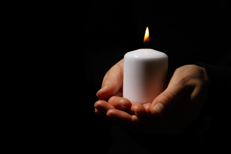 Hands holding a burning candle