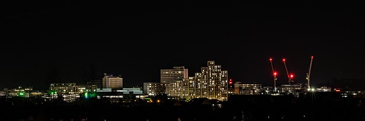 A photo of the Bracknell town centre at night, with a range of lights across the skyline.