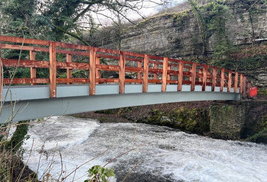 Wooden bridge crossing fast flowing river