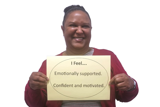 Social worker holding sign: I feel emotionally supported, confident and motivated.