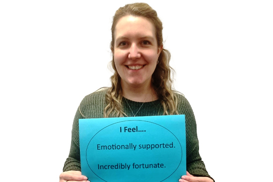 Social worker holding sign: "I feel... emotionally supported and incredibly fortunate."