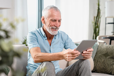 Smiling older man looking at a tablet device