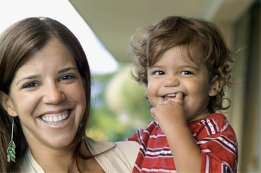 Smiling young mother holding toddler
