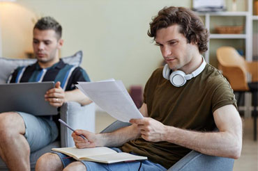 Students reading papers and laptops