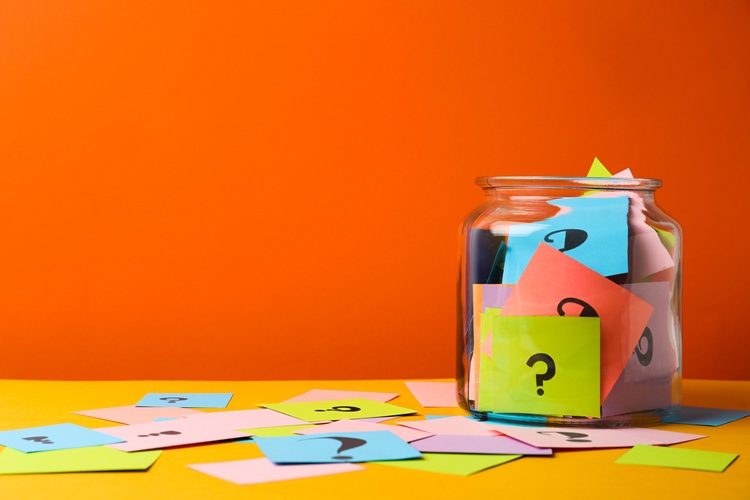 Jar with colourful cards, each with a question mark on