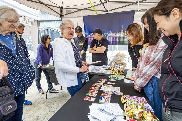 An older woman shares a joke with a stallholder at the Bracknell Community Festival