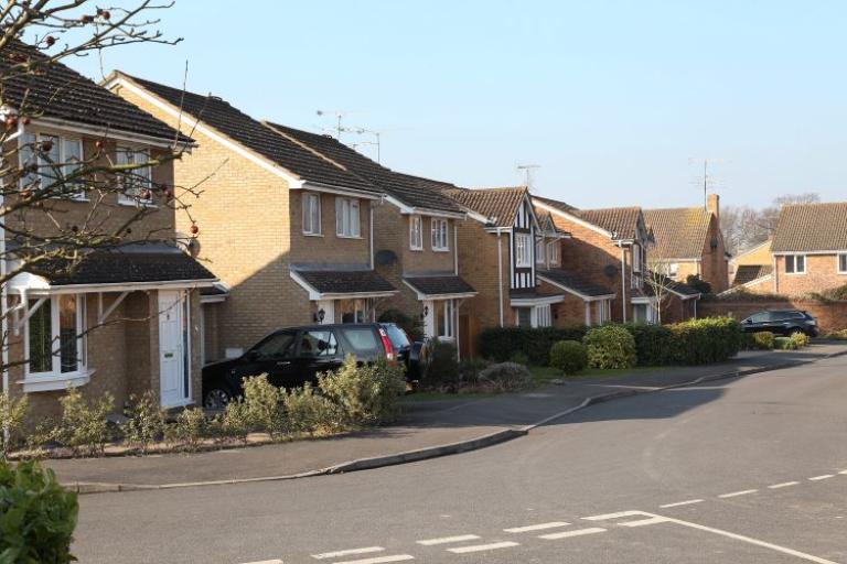 Row of houses with cars on the drive 