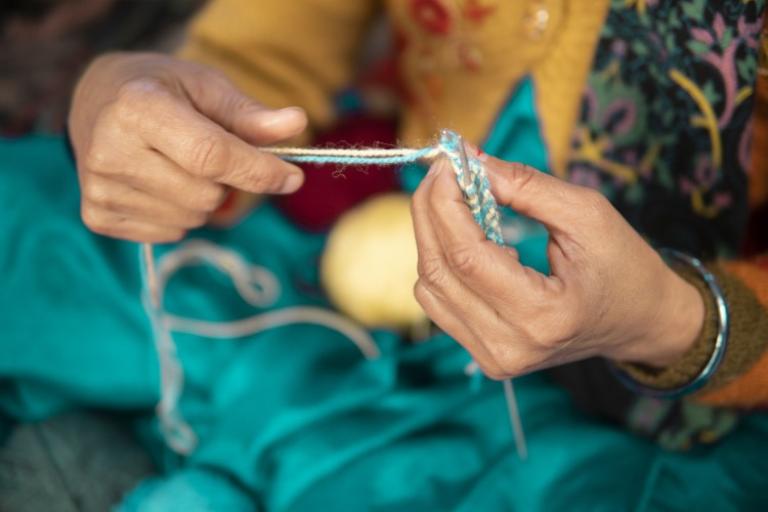 Close up of lady in beautiful sari doing crochet