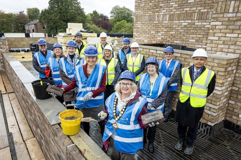group of adults in high vis jackets on a rooftop