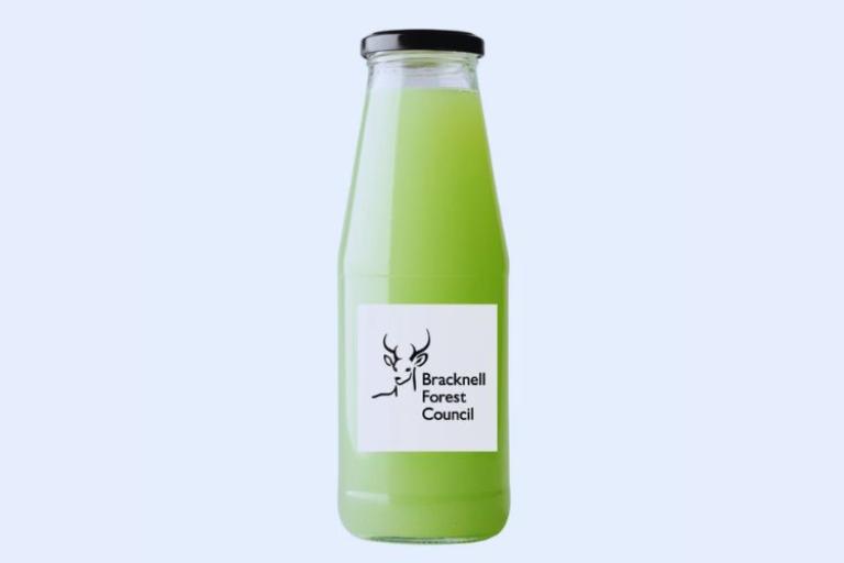 Glass bottle with green liquid in and a label on the bottle with the council's logo on it