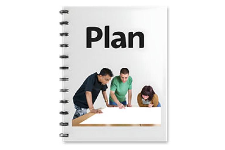 Notebook cover with the word 'Plan' and three people discussing a large sheet of paper at a table.