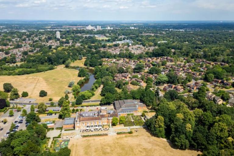 an ariel view over a park and houses with a town in the distance