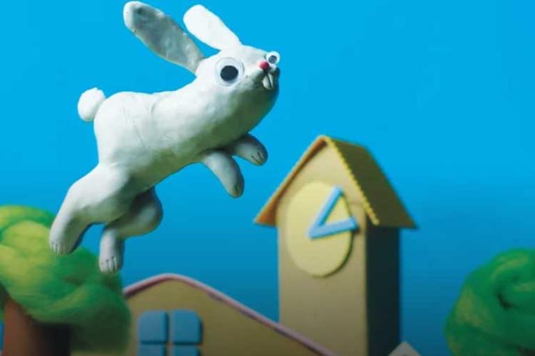 White rabbit jumping high in a blue sky