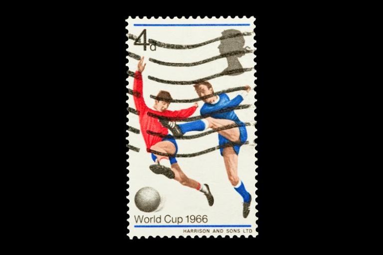 Vintage postage stamp showing two football players contesting the ball, overlaid with postal cancellation lines, with text “World Cup 1966” and a value of 4d