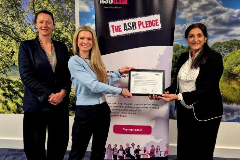 three women standing in front of a banner saying The ASB Pledge 