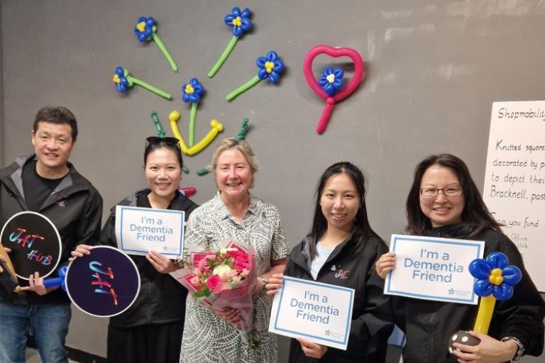 four women and a man holding signs saying I'm a dementia friend