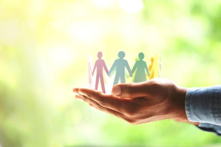a hand holding cut out people