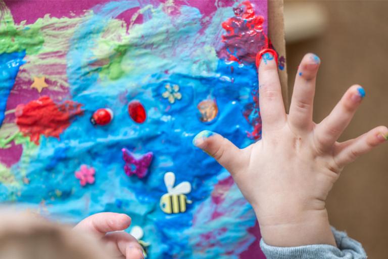 Toddler's hands and art project with finger paints