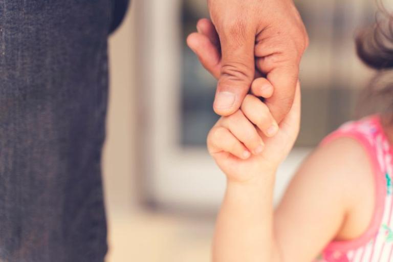 a young child holding an adult's hand