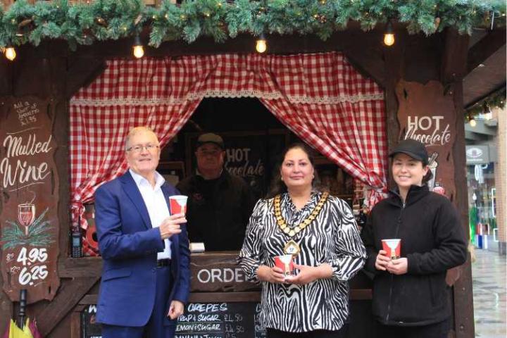 The mayor standing in front of a Christmas market stall