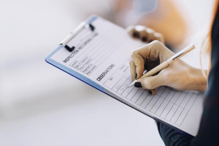 a person writing on a clipboard