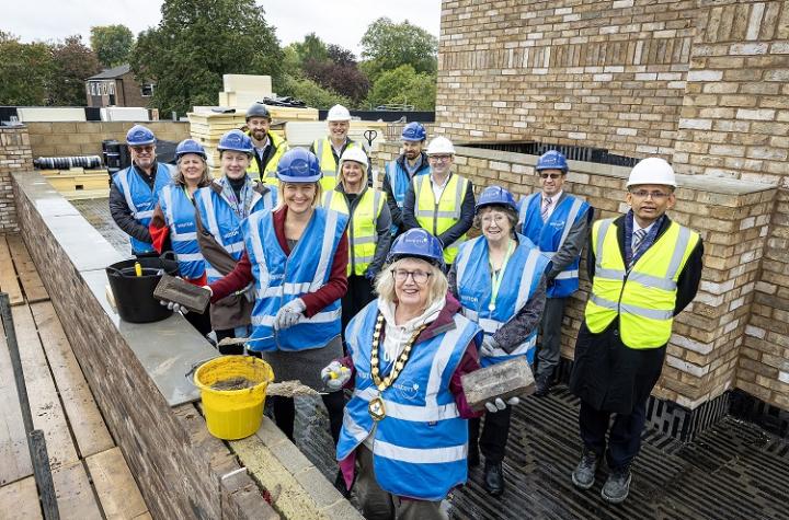 group of adults in high vis jackets on a rooftop