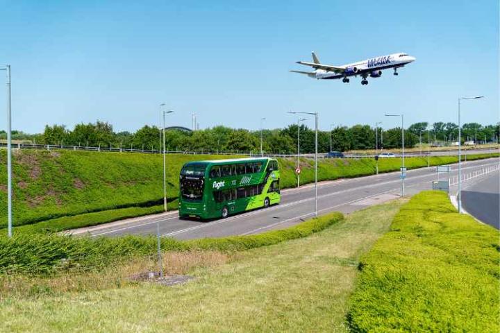 Bus on the way to Heathrow Airport with plane in the sky