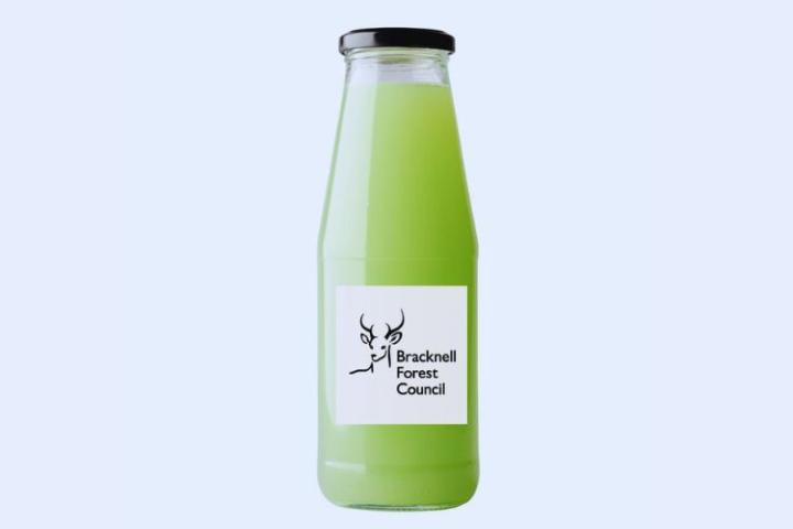 Glass bottle with green liquid in and a label on the bottle with the council's logo on it