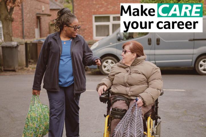 A caregiver speaks to a person in a wheelchair on a residential street, with brick houses and parked cars in the background. Text reads 'Make CARE your career.'