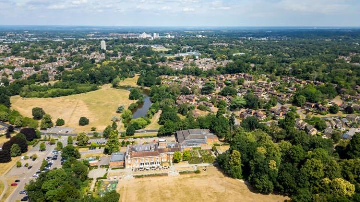 an ariel view over a park and houses with a town in the distance