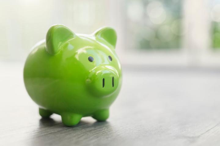 A green ceramic piggy bank on a table top 