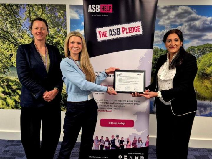 three women standing in front of a banner saying The ASB Pledge 