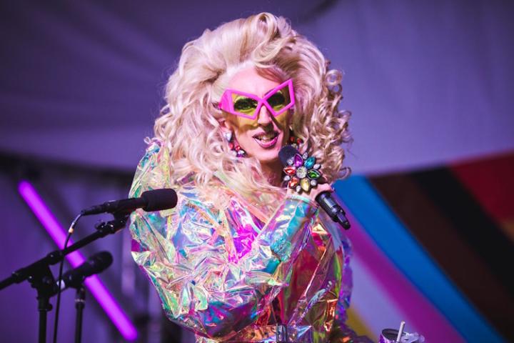 Bracknell's resident drag queen, Fonda Cox, performing on stage. She has big, blonde hair and wears a shimmering jacket.