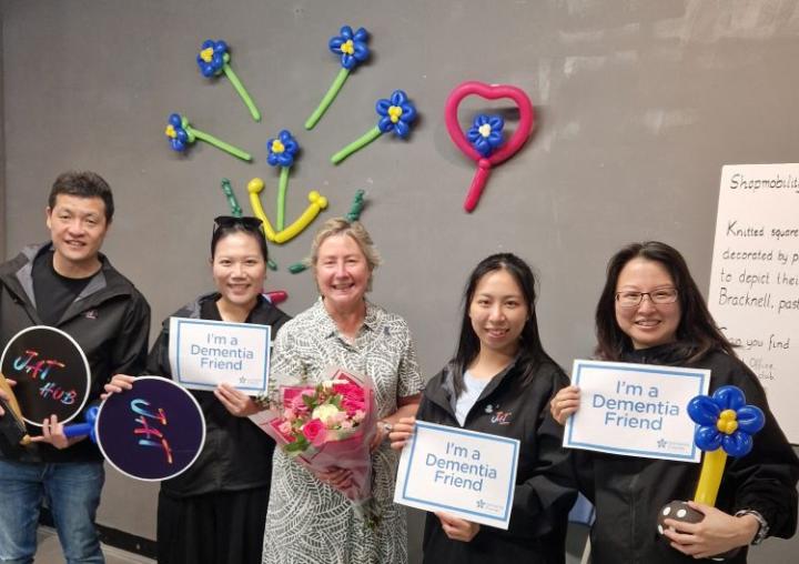 four women and a man holding signs saying I'm a dementia friend