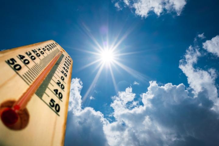 blue sky with sunshine, thermometer in bottom left corner showing high temperature