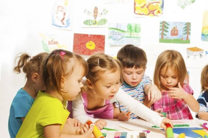 Young children doing crafts around a table