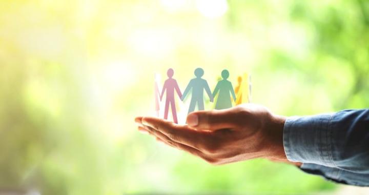 a hand holding cut out people