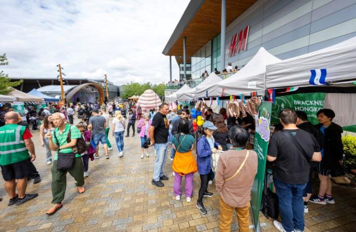 a group of people looking at stalls at a fair