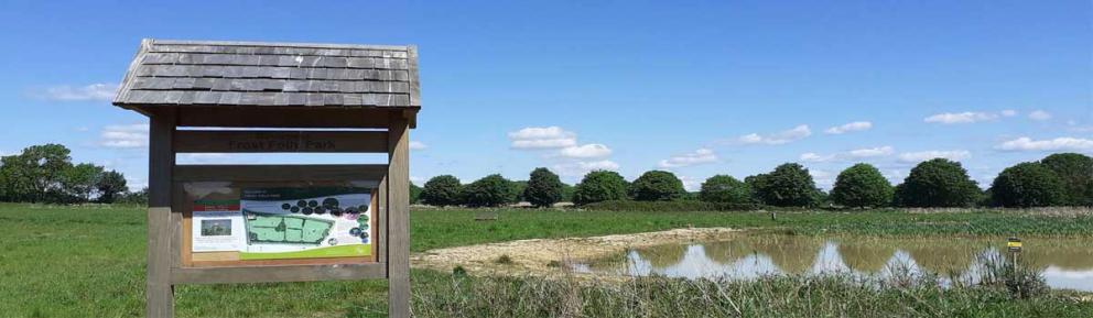 Noticeboard in foreground with parkland behind