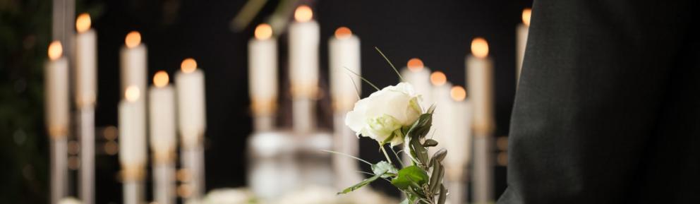 White rose with candles in the background.