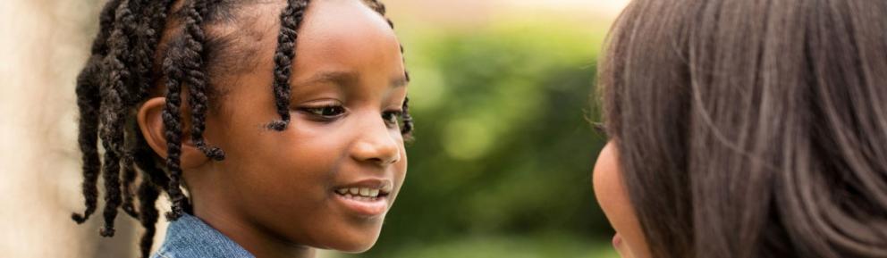 Two children smiling at each other.