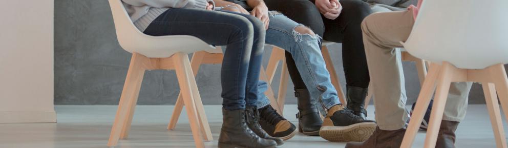 People wearing jeans sitting in a circle