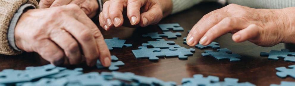 Two people starting to do a puzzle with pieces laid out on a table