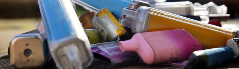 pile of discarded vapes on concrete outside