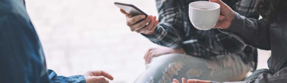 Group of people with coffee cups and phones