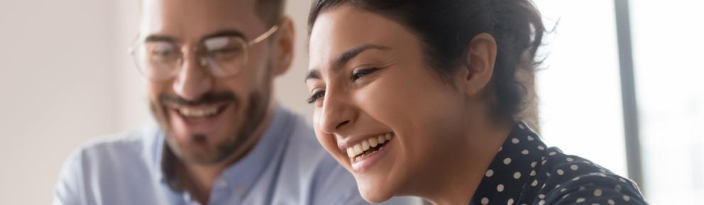 Young woman laughing with older male colleague