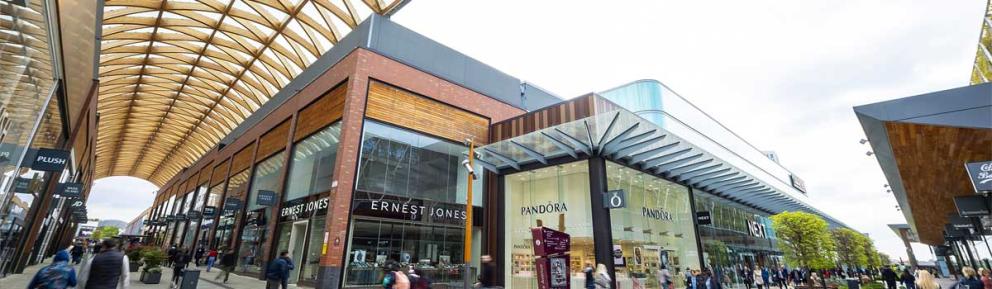 The Lexicon Bracknell, showing shops including Ernest Jones, Pandora and Next as well as a semi covered walkway with slatted wooden roof