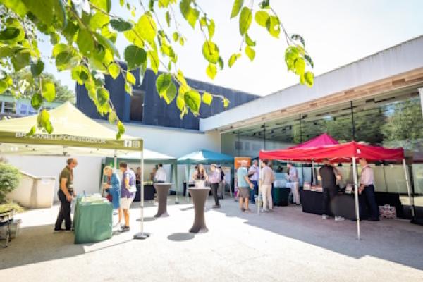 Several outdoor stands beneath brightly coloured gazebos at the Bracknell Forest Council Climate Summit.