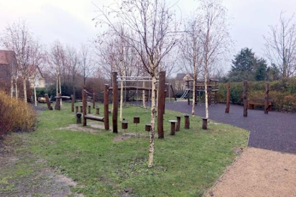 A photograph of a playground with a wooden balance beam trail.