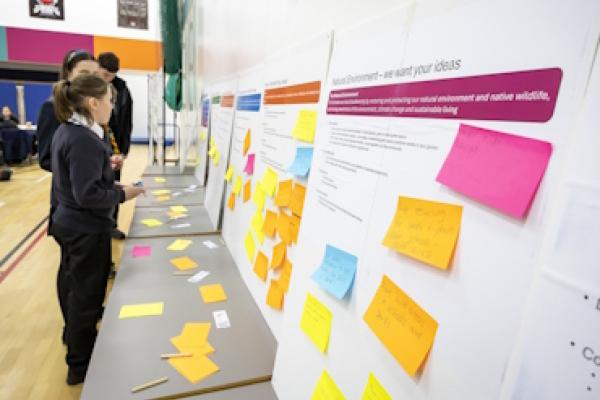 Students add brightly coloured post-it notes to boards.
